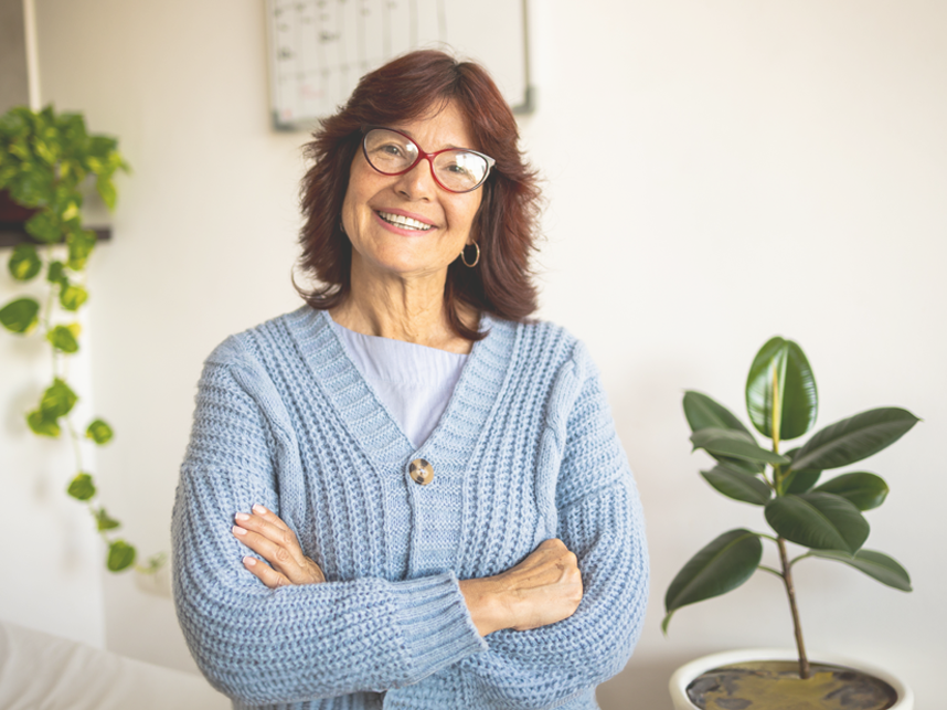 CTA-FullBleedModule-iStock1494044119-858x643px Confident mature woman wearing glassing smiling at camera wearing a blue cardigan.