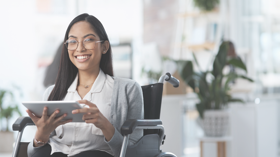 NDISHomepage-ProgramHeaderBanner-924x520px-iStock-1325242956 Portrait of a young businesswoman in a wheelchair using her tablet in an office environment.