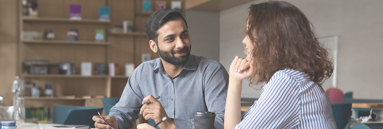 PBAS-CampaignLandingPageHeaderBanner-1248x420px-iStock-1314904278 Interview of happy smiling Indian worker and young professional providing friendly support and discussing job resume.