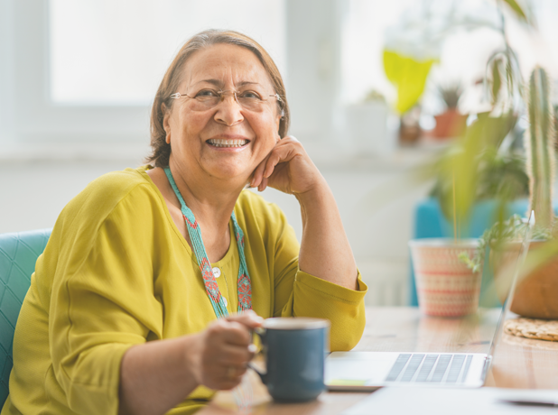SEA -BodyImage-iStock-1343844574-618x460px A portrait of a happy hispanic senior woman smiling for the camera while using a laptop at home.