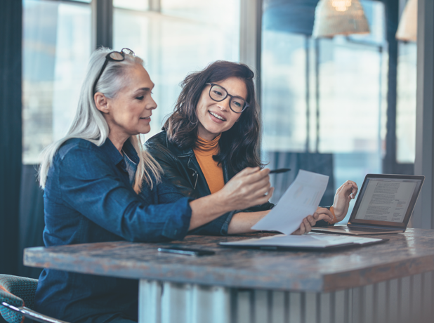 SEA -BodyImage-iStock-1018188310-618x460px Two mixed-race female executives at work in the office discussing some paperwork.