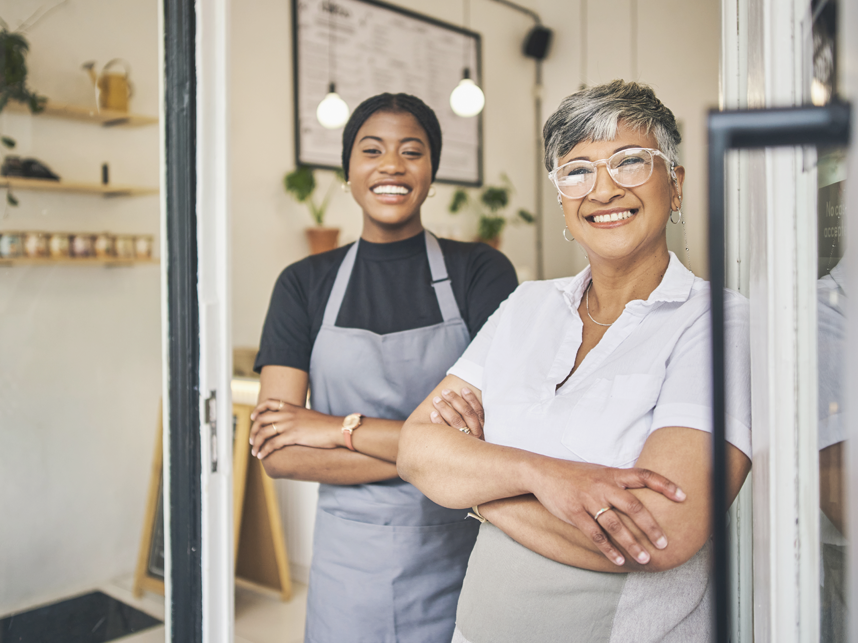 SEA - Split Text and Media full bleed - 858x643px_19b - July 24 Coffee shop, senior woman manager portrait with barista feeling happy about shop success. Female server, waitress and small business owner together proud of cafe and bakery growth with a smile