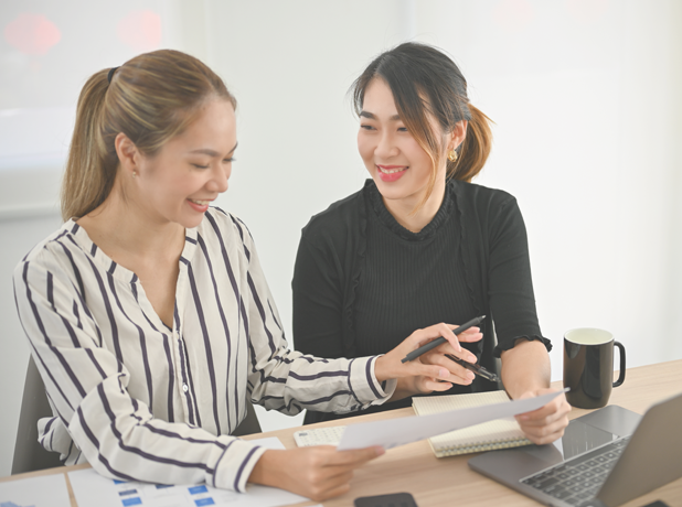 The MTC Difference-MediaTextSplitModule-618x460px-iStock-1459581640 An image of two women having a consultation at a desk with coffee and a laptop.