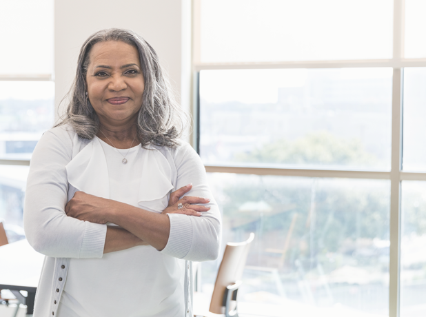 The MTC Difference-MediaTextSplitModule-618x460px-iStock-1472972329 An image of a middle aged woman in a casual setting smiling and looking at the camera.