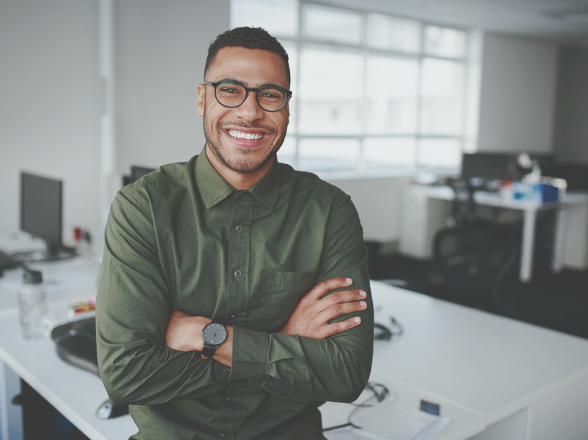 VETTraineeship-FullBleedModule-iStock-1178152960-858x643px Portrait of a happy confident young african american businessman standing with his arms crossed looking at camera.