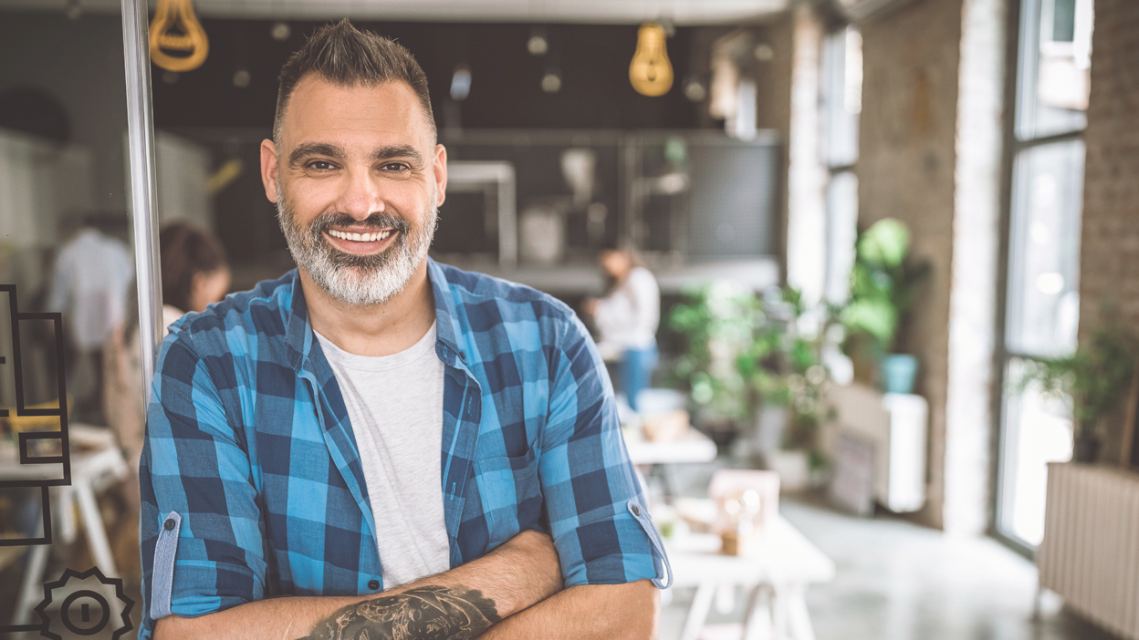 WFA - Full Image - 1248x702px_iStock-1163825396 Middle eastern mid age man in a casual office setting looking at the camera and smiling.