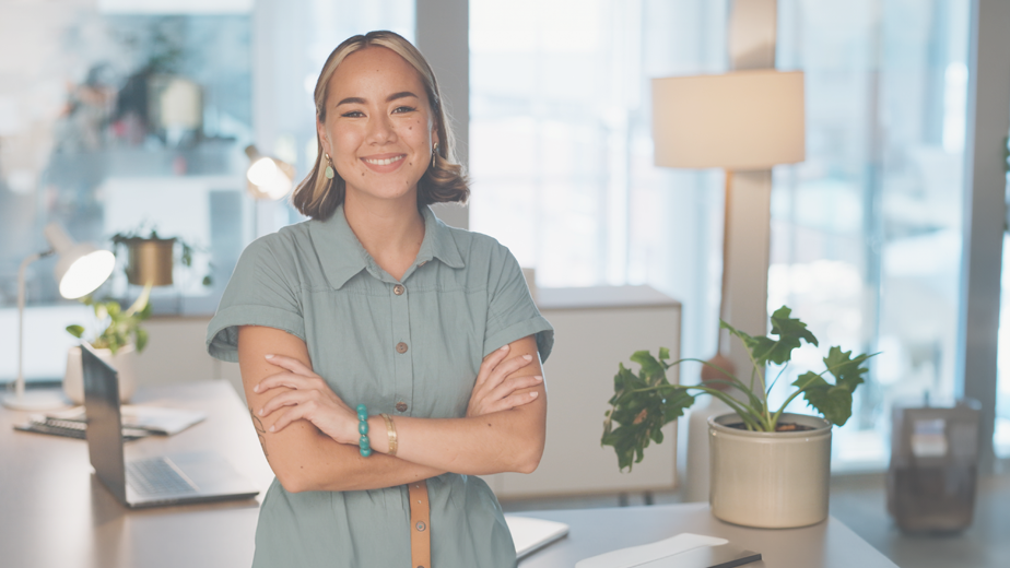 YouthPage-ProgramPageHeaderBanner-924x520-iStock-1682933861 A young lady in a casual office environment smiling and looking at the camera.