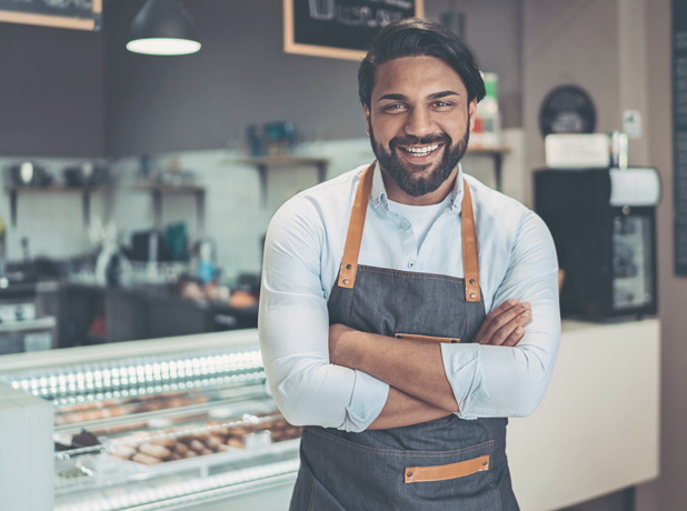 EST-BodyImageModule-iStock-1214546882-618x460px8 Cheerful Indian male small business owner looking to camera smiling confidently