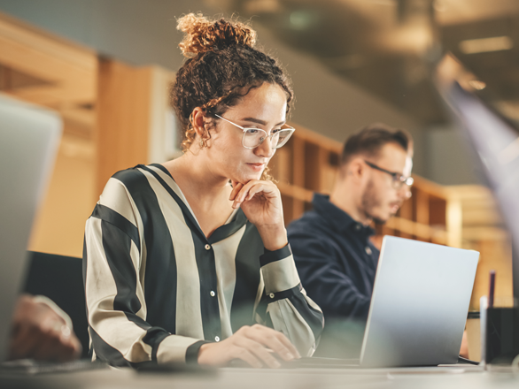 Employers-CampaignTitleCards-iiStock-1481370371-518x440px A woman wearing glasses looking at her laptop.