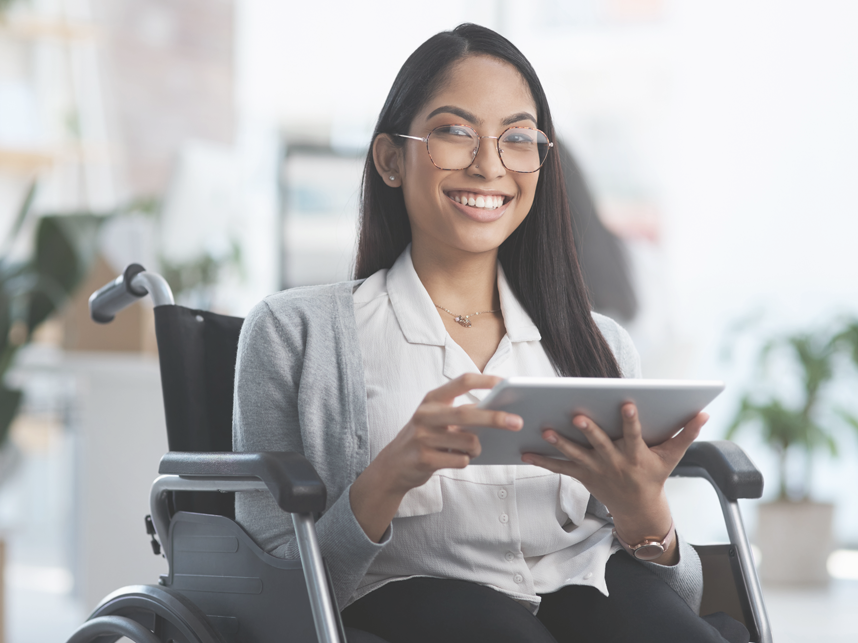 NDIS-FullImage 858x643-iStock-1325242956 Portrait of a young businesswoman in a wheelchair using her tablet in an office environment.