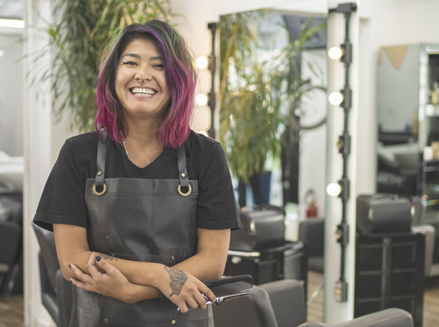 SEA -BodyImageModule-iStock-1398386378-618x460px Portrait of Asain female hairdresser with pink dyed hair at hair salon holding scissors.