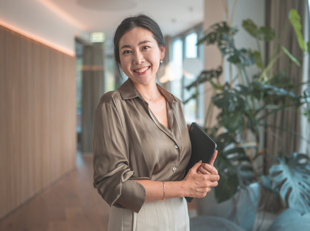 VET-BodyImageModule-istock724657496-618x460px Smiling Female Korean Corporate Employee with Digital Device smiling to camera.