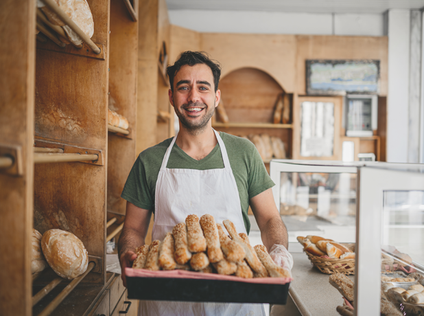 VET - Module 618x460px_5c(Business) Male baker holding a basket of fresh bread in his bakery business.