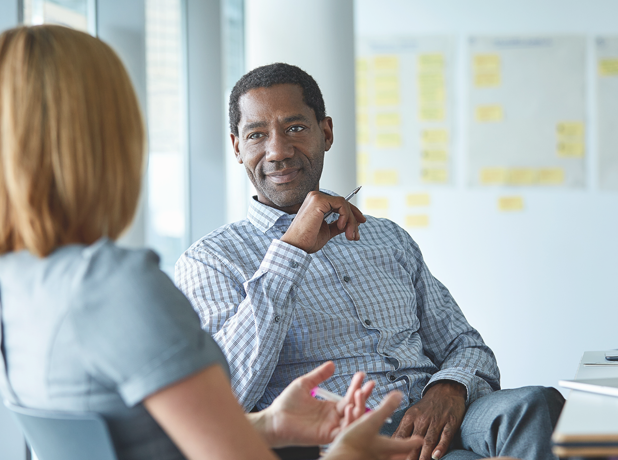 SEE-BodyImageModule-iStock-533719066-618x460px African male having an in-depth discussion with female colleague in a workpalce.