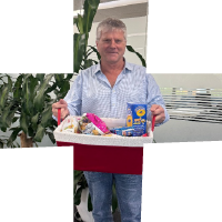Participant Peter standing holding a basket of products looking at the camera.