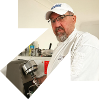 MTC_Web_HP_GNS_200x200px_StephenWatson (1) Chef Stephen standing in the kitchen looking at the camera.