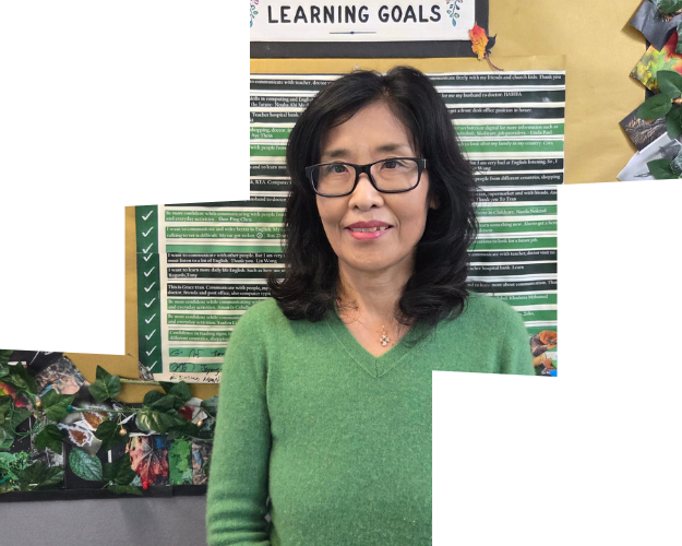 Keum standing in front of a notice board, wearing a green sweater and smiling. 